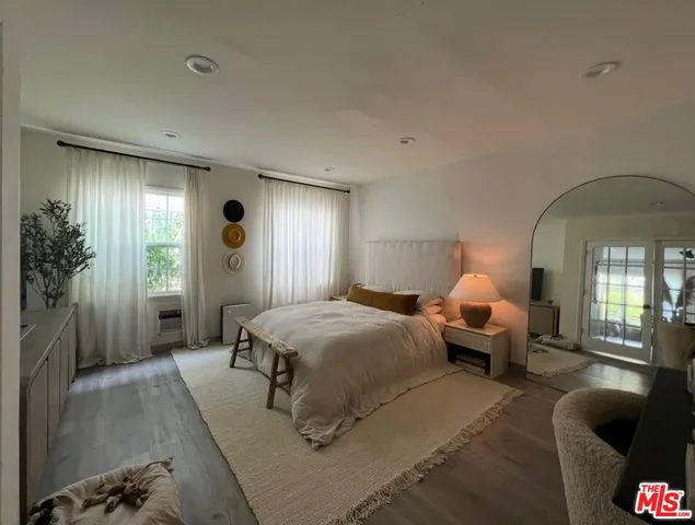 a spacious bedroom with a bed and a chandelier