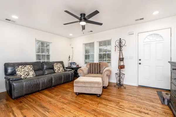 a living room with furniture and a wooden floor