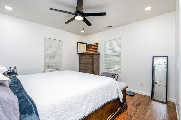 a bedroom with a bed and wooden floor