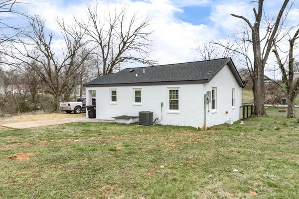 a white house that has a tree in front of it