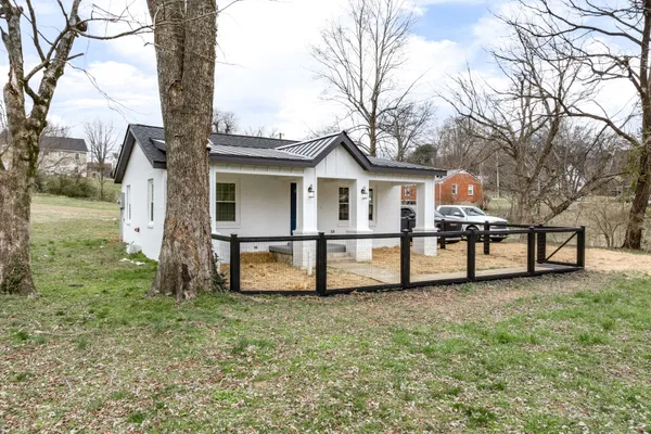 a view of a house with yard and a tree