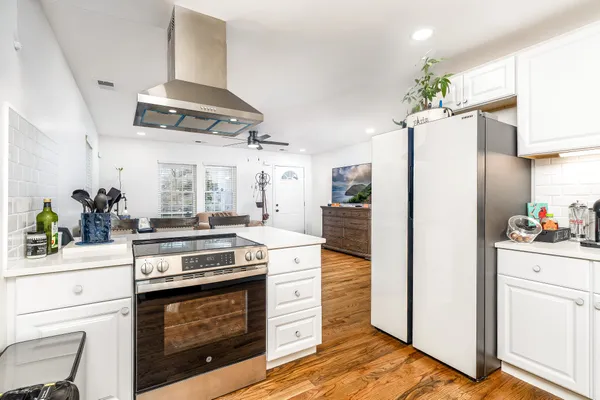 a kitchen with stainless steel appliances a stove a refrigerator and cabinets
