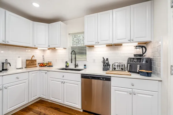 a kitchen with white cabinets and white appliances