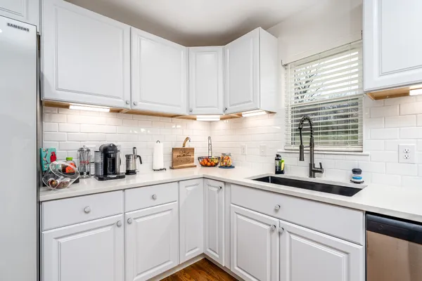 a kitchen with white cabinets and white appliances