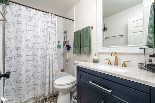 a bathroom with a granite countertop sink a toilet and a mirror