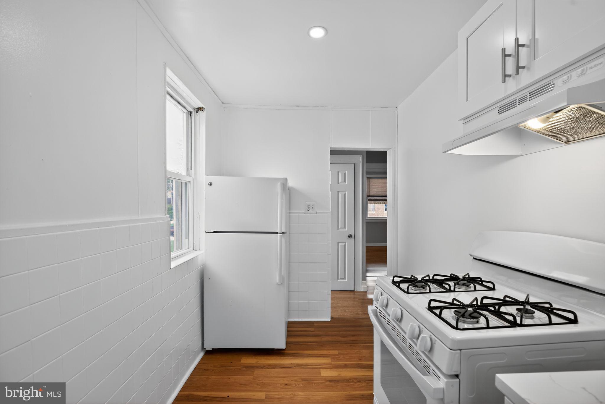 5446 Narcissus Avenue, Unit 2 Baltimore, MD 21215 - Photo 11 of 18 a kitchen with a stove and a refrigerator