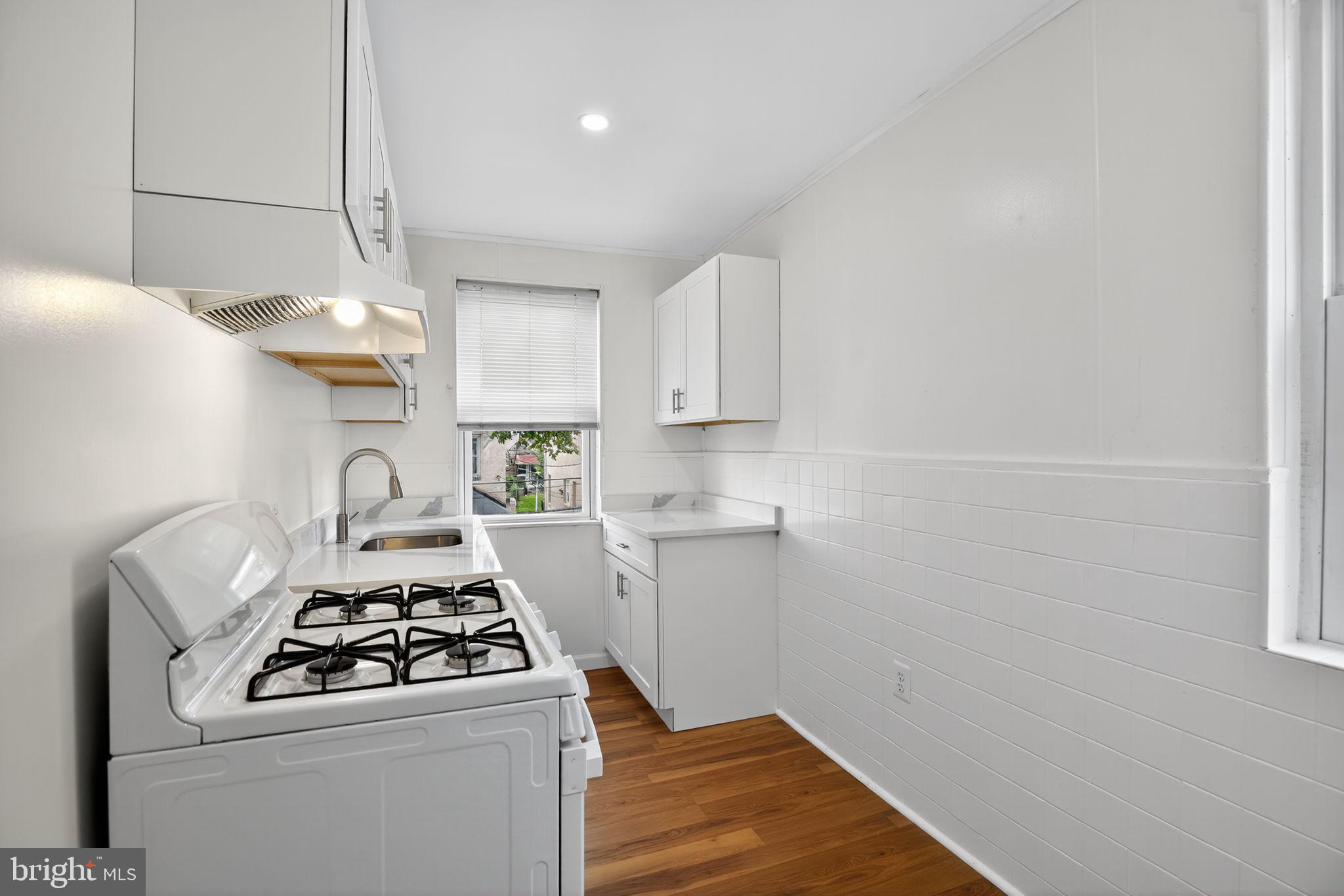 5446 Narcissus Avenue, Unit 2 Baltimore, MD 21215 - Photo 13 of 18 a kitchen with a stove and a refrigerator