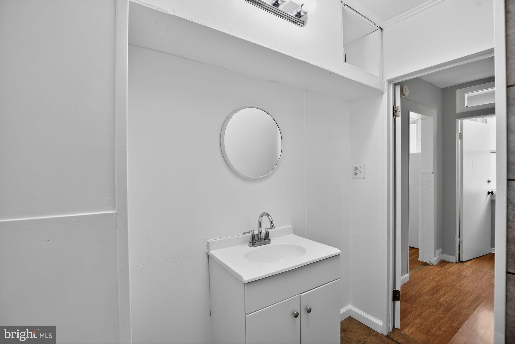5446 Narcissus Avenue, Unit 2 Baltimore, MD 21215 - Photo 15 of 18 a bathroom with a sink and a mirror