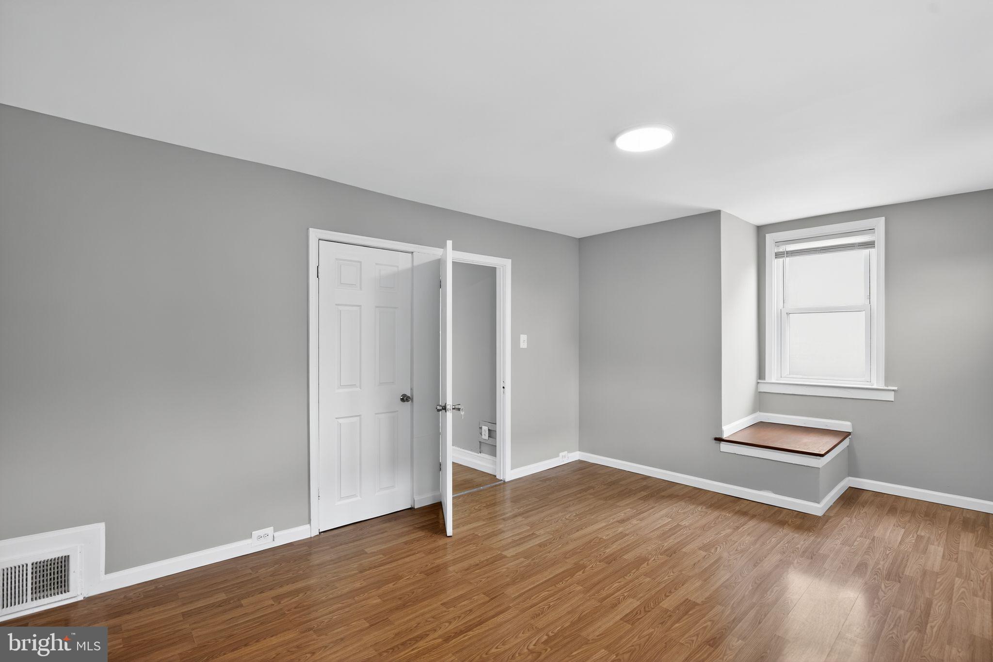 5446 Narcissus Avenue, Unit 2 Baltimore, MD 21215 - Photo 18 of 18 an empty room with wooden floor and windows