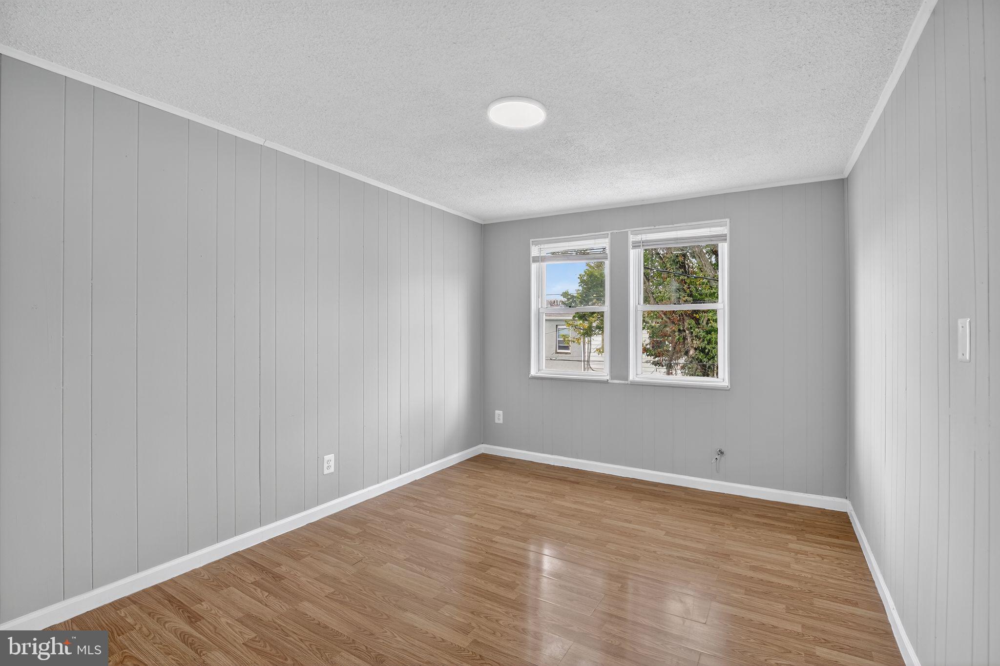 5446 Narcissus Avenue, Unit 2 Baltimore, MD 21215 - Photo 10 of 18 wooden floor in an empty room with a window
