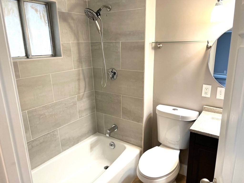 150 Locust Street, Unit 1 Winthrop, MA 02152 - Photo 10 of 11 a white toilet sitting next to a bath tub and shower