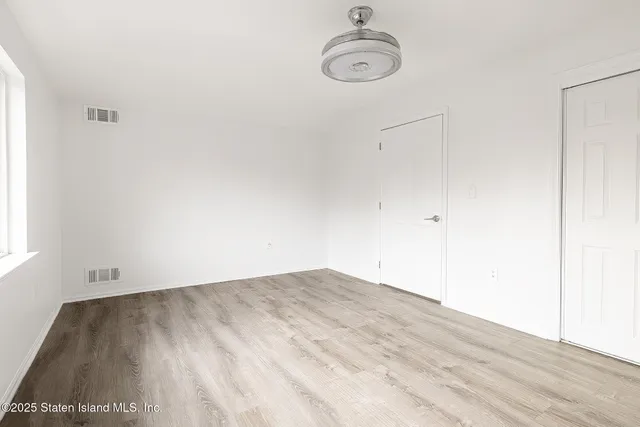 a view of a room with wooden floor and a window