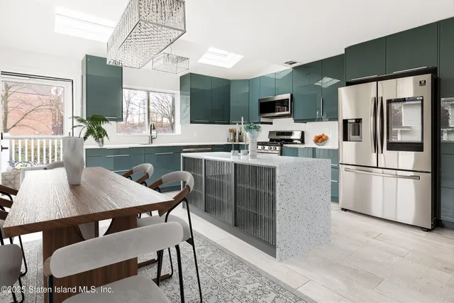 a kitchen with stainless steel appliances a dining table chairs microwave and sink