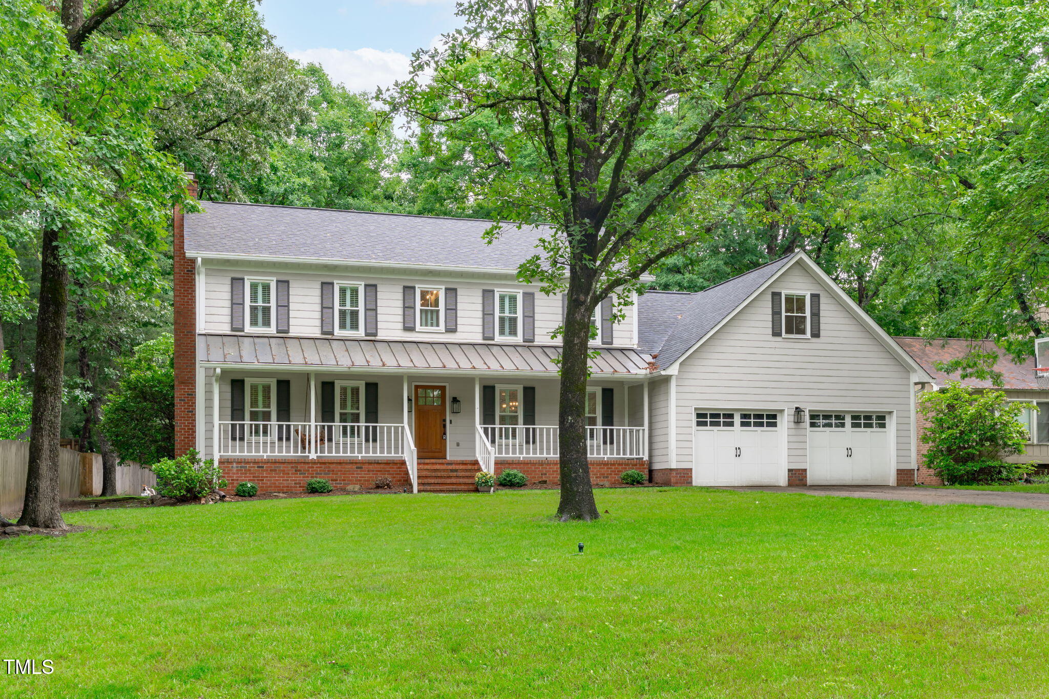 a front view of a house with a yard and green space