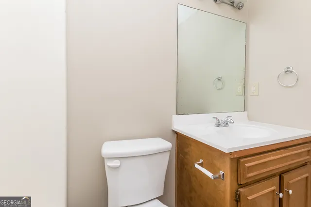 a bathroom with a sink a toilet and a mirror