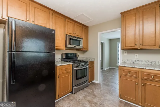 a kitchen with stainless steel appliances granite countertop a refrigerator a stove a sink and dishwasher