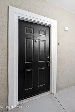 an empty room with an entryway and fan