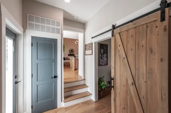 a view of a hallway with wooden floor and entryway