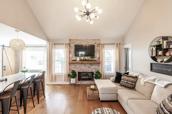 a living room with furniture a fireplace and a flat screen tv