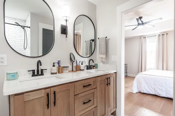a en suite bathroom with a granite countertop double vanity sinks and a mirror