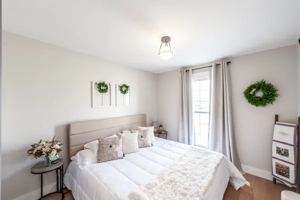 a bedroom with a bed table and a window