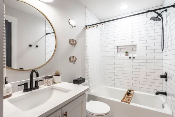 a bathroom with a sink vanity granite toilet tub and shower