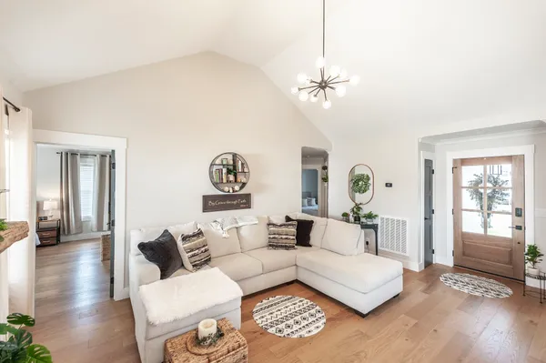 a living room with furniture a chandelier and a window