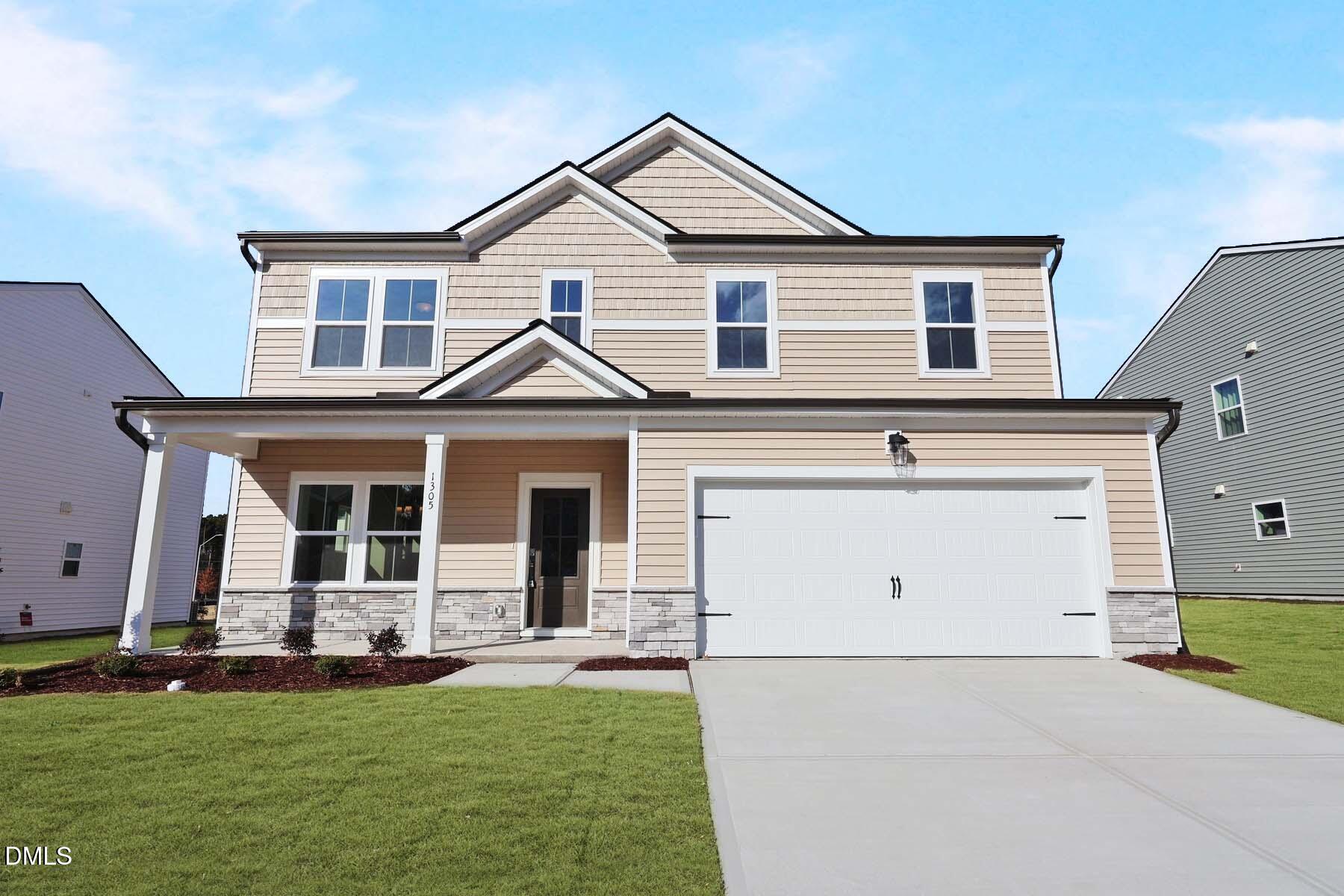 a view of a white house with a big yard and potted plants