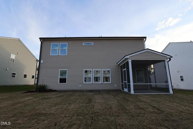 a view of a house with a small yard and wooden fence