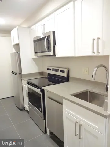 a kitchen with stainless steel appliances granite countertop a sink and a microwave