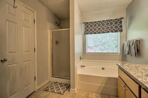 a bathroom with a granite countertop shower and a sink
