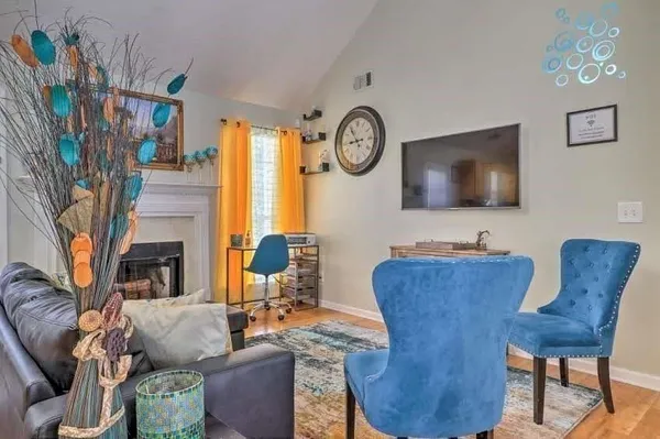 a living room with furniture a flat screen tv and a fireplace