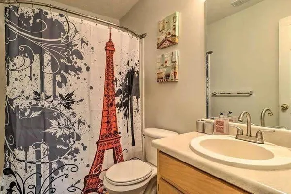 a bathroom with a toilet sink and shower curtain