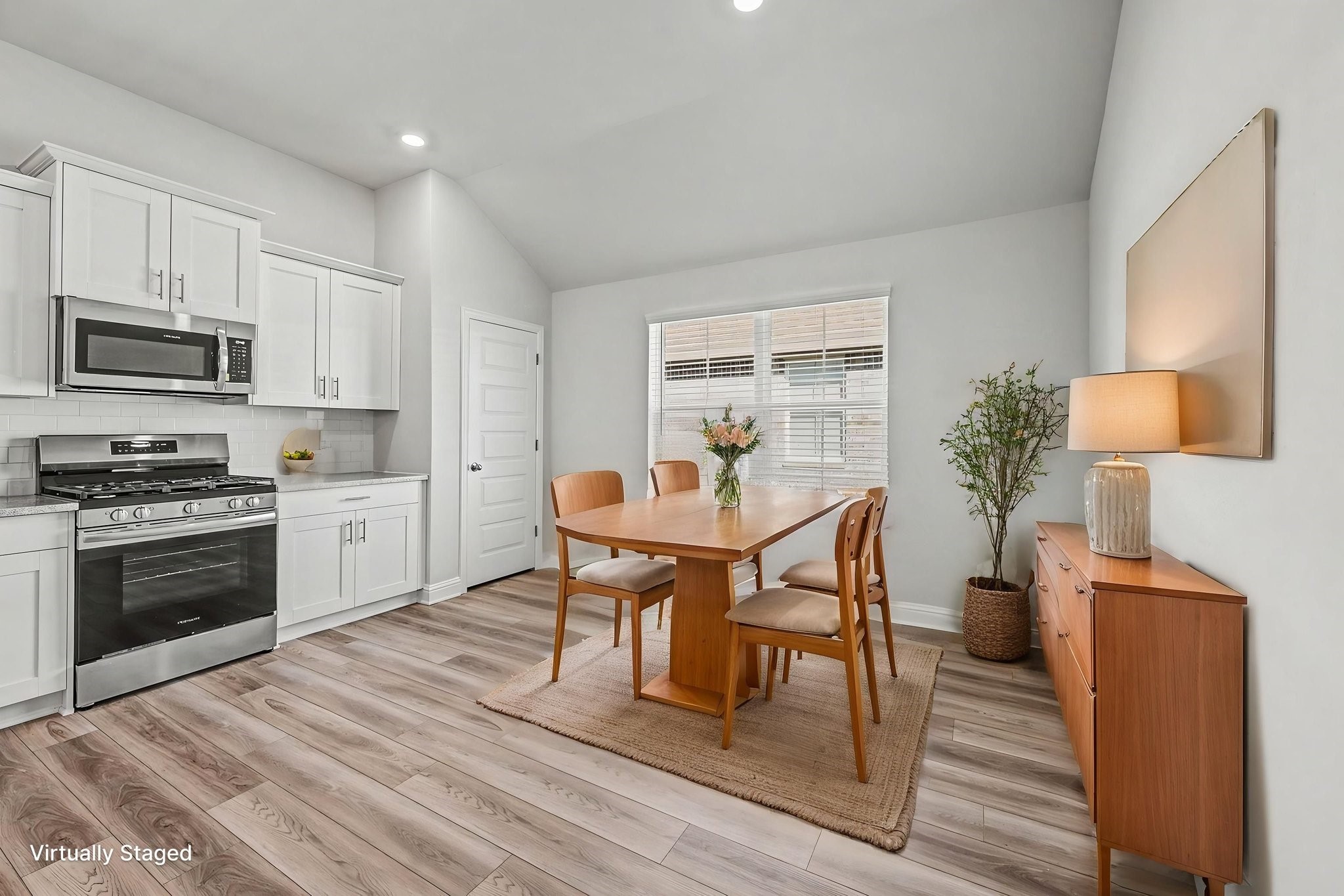 601 Greystone Lane Angleton, TX 77515 - Photo 12 of 32 a kitchen with stainless steel appliances a stove a sink a microwave a dining table and chairs with wooden floor