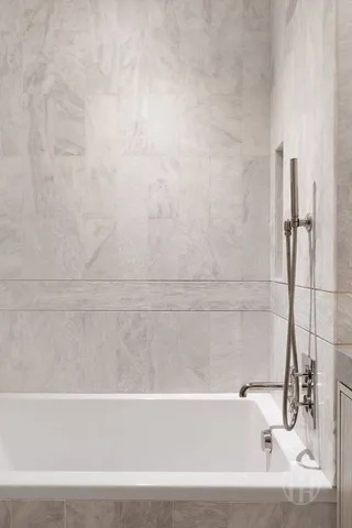 a bathroom with a granite countertop bathtub shower sink mirror and toilet