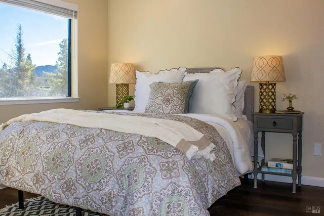 a large bed sitting in a bedroom next to a window