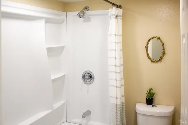 a bathroom with a shower a toilet and a shower