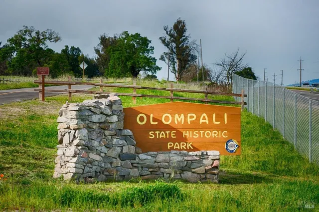 a sign of golf club on a wall with a park