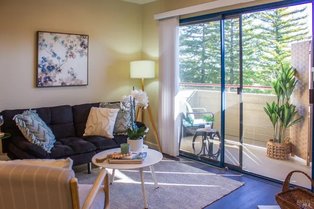 a living room with furniture and a large window with wooden floor