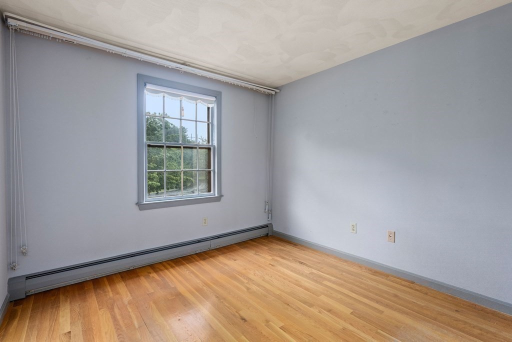 4 Woodpark Circle Lexington, MA 02421 - Photo 18 of 27 a view of an empty room with wooden floor and a window