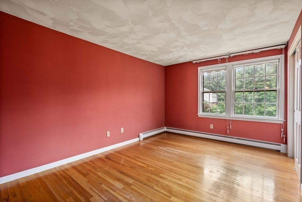 4 Woodpark Circle Lexington, MA 02421 - Photo 21 of 27 an empty room with wooden floor and windows
