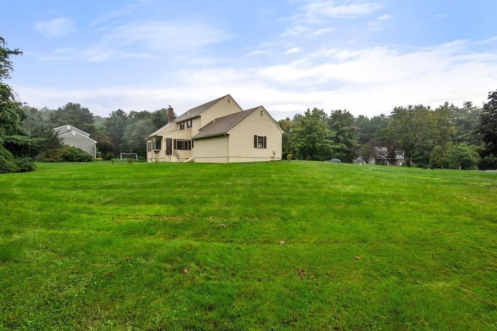 4 Woodpark Circle Lexington, MA 02421 - Photo 26 of 27 a house with huge green field in front of it