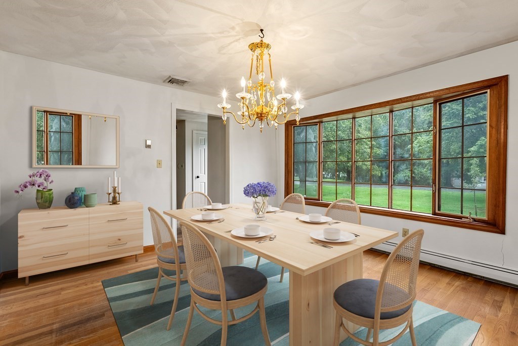 4 Woodpark Circle Lexington, MA 02421 - Photo 6 of 27 a dining room with wooden floor a chandelier a glass table and chairs