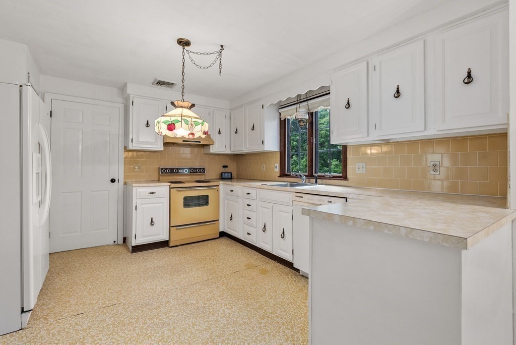 4 Woodpark Circle Lexington, MA 02421 - Photo 7 of 27 a kitchen that has a lot of white cabinets and stainless steel appliances