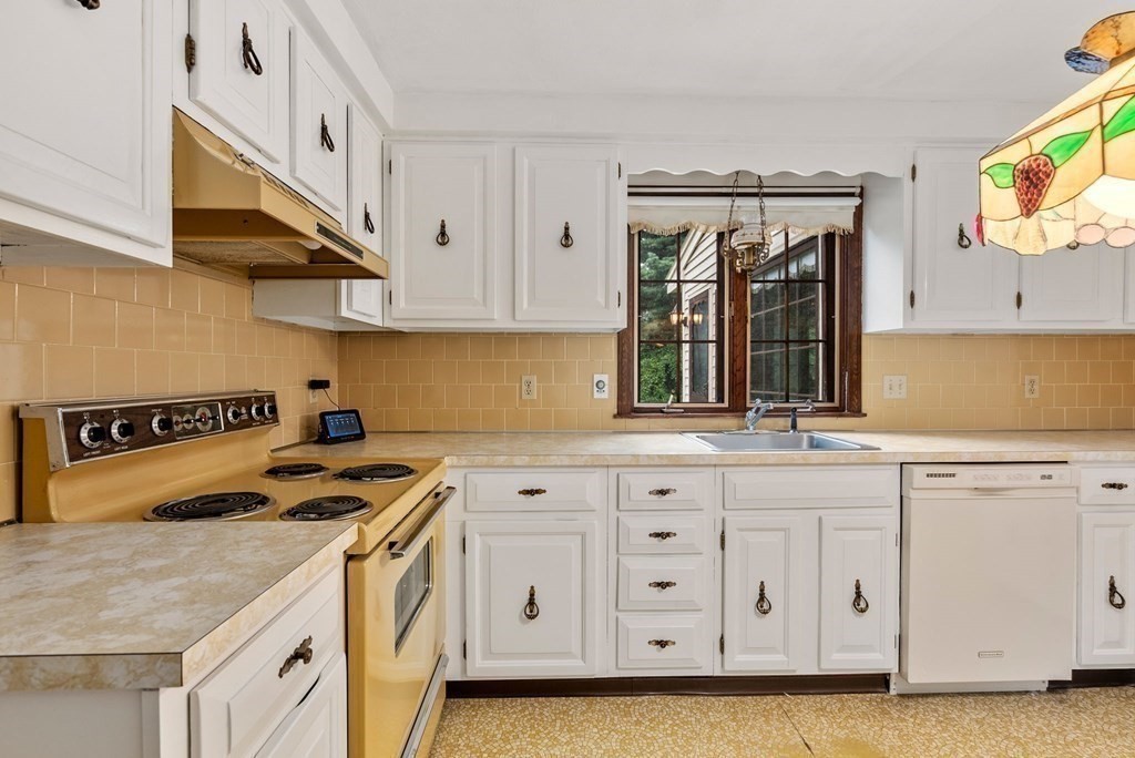 4 Woodpark Circle Lexington, MA 02421 - Photo 9 of 27 a kitchen with granite countertop a sink a stove and cabinets