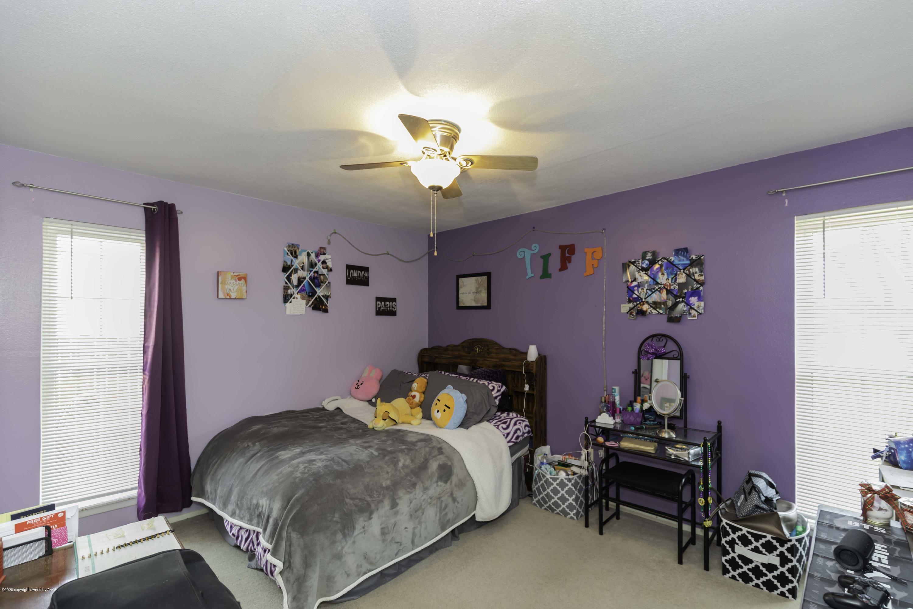 4616 South Georgia Street Amarillo, TX 79110 - Photo 22 of 36 a bedroom with a bed and a chandelier