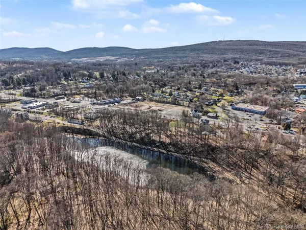 an aerial view of house with yard and mountain view in back