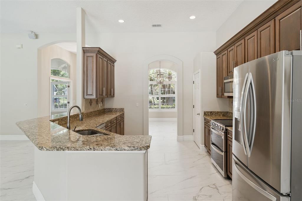 2230 Ridgewind Way Windermere, FL 34786 - Photo 15 of 38 a kitchen with stainless steel appliances granite countertop a refrigerator a oven and a sink