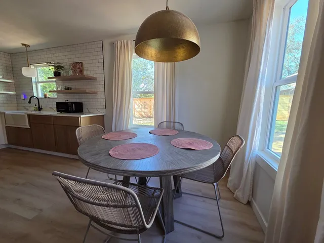 a dining room with furniture a chandelier and wooden floor