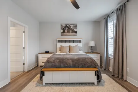 a bedroom with a bed and painting on the wall